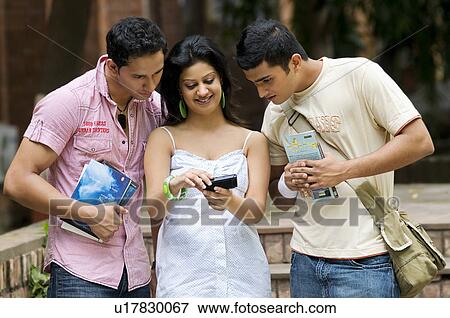 Students looking at mobile phone View Large Photo Image Stock Photo - Students looking at mobile phone. Fotosearch