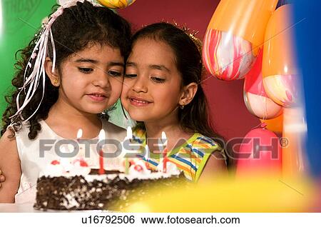 Stock Photograph - Two girls with a birthday cake. Fotosearch