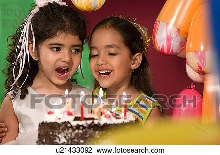 Stock Image - Two girls with birthday cake. Fotosearch