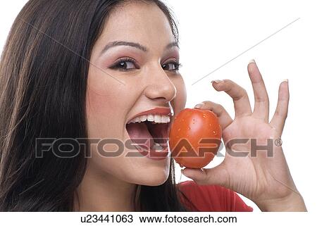 Woman about to eat a tomato View Large Photo Image Stock Image - Woman about to eat a tomato. Fotosearch