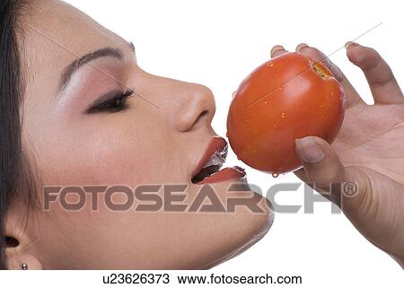 Woman about to eat a tomato View Large Photo Image Stock Image - Woman about to eat a tomato. Fotosearch