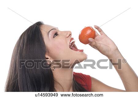 Stock Photo - Woman about to eat a tomato. Fotosearch