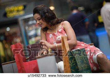 Stock Image - Woman admiring her shopping. Fotosearch