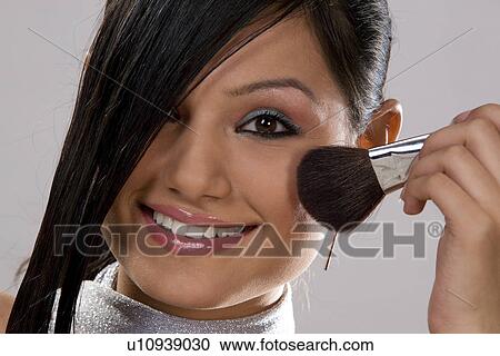 Stock Image - Woman applying make-up. Fotosearch