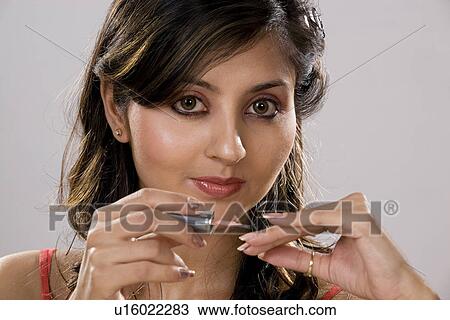 Stock Image - Woman applying nail polish. Fotosearch