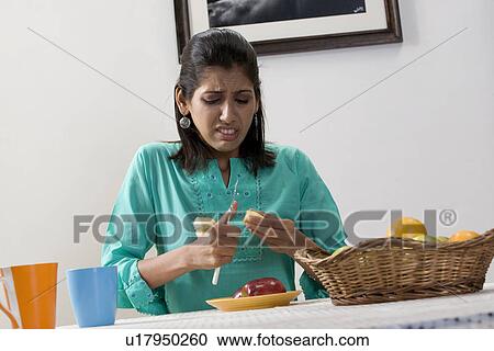 Stock Image - Woman cutting fruit. Fotosearch