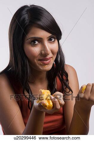 Woman eating a Mango View Large Photo Image Stock Photograph - Woman eating a Mango. Fotosearch
