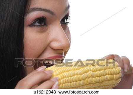 Woman eating a piece of corn View Large Photo Image Stock Image - Woman eating a piece of corn. Fotosearch