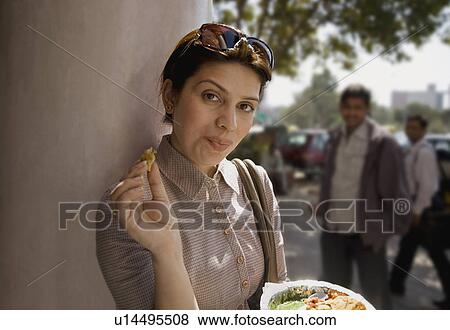Woman having street food View Large Photo Image Stock Photo - Woman having street food. Fotosearch