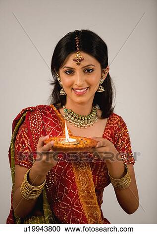 Stock Image - Woman holding a diya. Fotosearch