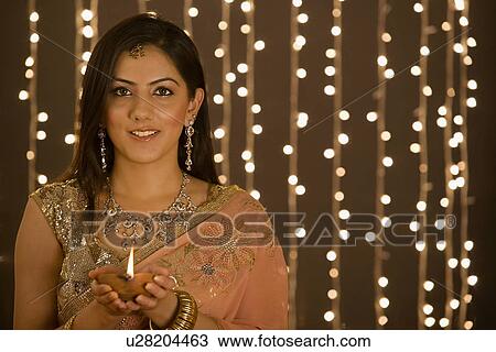 Stock Image - Woman holding a diya. Fotosearch