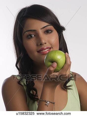Stock Photography - Woman holding a green apple. Fotosearch