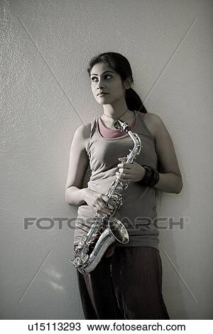 Stock Image - Woman holding a saxophone. Fotosearch