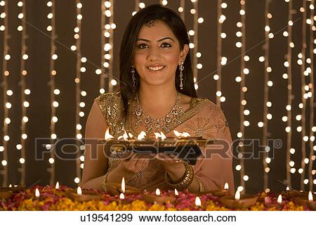 Woman holding a tray of diyas View Large Photo Image Stock Photo - Woman holding a tray of diyas. Fotosearch