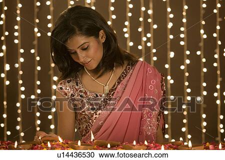 Stock Image - Woman lighting diyas. Fotosearch