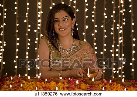 Woman lighting diyas View Large Photo Image Stock Photograph - Woman lighting diyas. Fotosearch