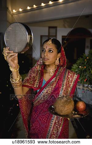 Woman looking at the moon during Karwa Chauth View Large Photo Image Stock Image - Woman looking at the moon during Karwa Chauth. Fotosearch