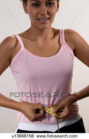 Stock Photo - Woman measuring her waist. Fotosearch