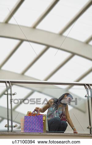 Woman on cell phone while shopping View Large Photo Image Picture - Woman on cell phone while shopping. Fotosearch