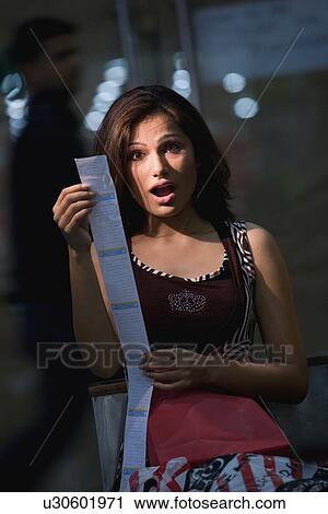 Stock Image - Woman reacts to shopping bill. Fotosearch