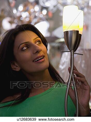 Woman selecting a lamp View Large Photo Image Stock Photo - Woman selecting a lamp. Fotosearch