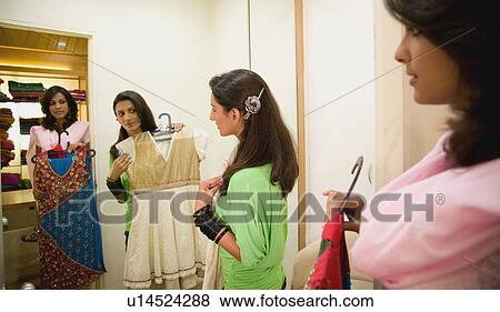 Stock Photo - Woman selecting clothes. Fotosearch