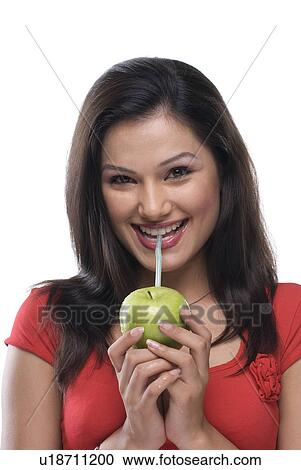 Stock Image - Woman sipping juice . Fotosearch