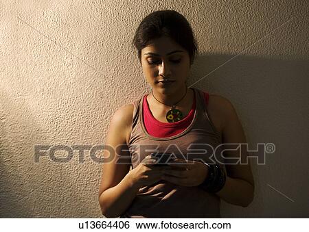 Stock Photograph - Woman using her mobile phone. Fotosearch