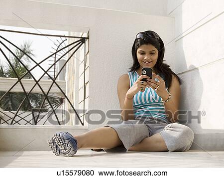 Stock Image - Woman with her mobile phone. Fotosearch