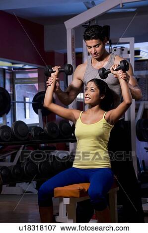Woman with trainer at the gym View Large Photo Image Stock Photo - Woman with trainer at the gym. Fotosearch