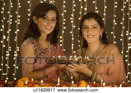 Women holding a tray of diyas View Large Photo Image Stock Photo - Women holding a tray of diyas. Fotosearch