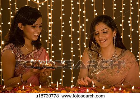 Women lighting diyas View Large Photo Image Stock Photo - Women lighting diyas. Fotosearch