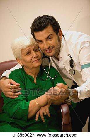 Young doctor comforting his patient View Large Photo Image Stock Photo - Young doctor comforting his patient. Fotosearch