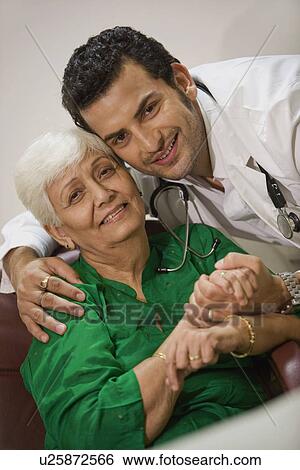 Young doctor comforting his patient View Large Photo Image Stock Photograph - Young doctor comforting his patient. Fotosearch