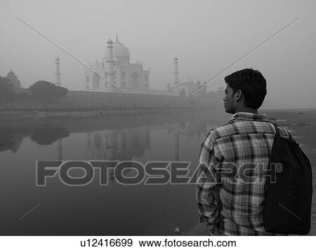 Stock Photo - Back view of a man looking at the Taj Mahal in India. Fotosearch