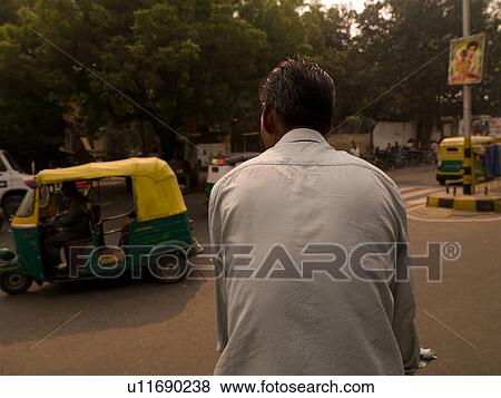 Back view of a man riding a bicycle in Delhi India View Large Photo Image Stock Photo - Back view of a man riding a bicycle in Delhi India. Fotosearch