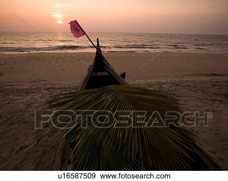 Stock Photo - "Boat covered with a flag on the Arabian Sea beach, Kerala, India". Fotosearch