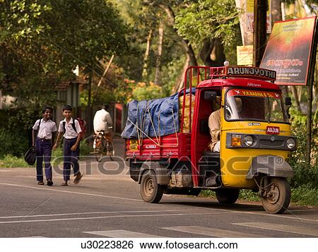 Boys walking beside truck on a road in India View Large Photo Image Stock Photograph - Boys walking beside truck on a road in India. Fotosearch