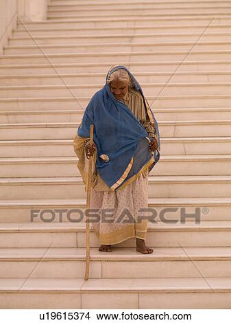 Picture - Elderly woman walking down stairs in India. Fotosearch