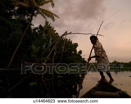 Stock Image - Fisherman on his boat in India. Fotosearch