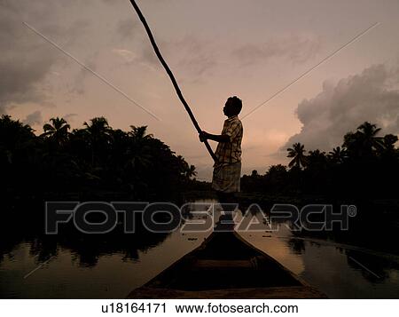 Stock Image - Fisherman on his boat in India. Fotosearch
