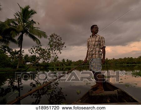 Stock Image - Fisherman on his boat in India. Fotosearch