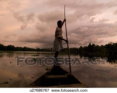 Stock Photo - Fisherman on his boat in India. Fotosearch