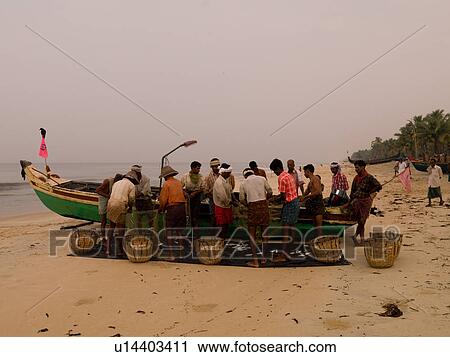 Fishermen filling baskets beside boat on beach View Large Photo Image Stock Image - Fishermen filling baskets beside boat on beach. Fotosearch