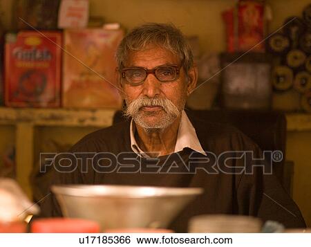 Stock Photograph - Indian man sitting at a table in India. Fotosearch
