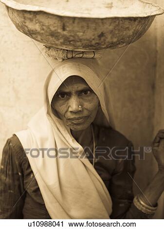Indian woman balancing a bowl on her head View Large Photo Image Stock Image - Indian woman balancing a bowl on her head. Fotosearch