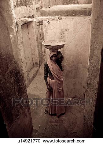 Indian woman balancing a bowl on her head View Large Photo Image Stock Image - Indian woman balancing a bowl on her head. Fotosearch