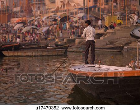 Man directing his boat on the Ganges River in India View Large Photo Image Stock Image - Man directing his boat on the Ganges River in India. Fotosearch