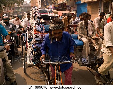 Man hauling cloth on bicycle in India View Large Photo Image Stock Image - Man hauling cloth on bicycle in India. Fotosearch