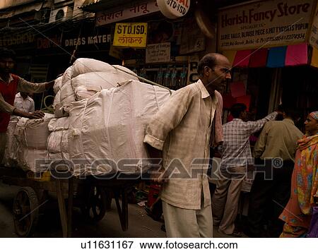 Stock Photo - Man pulling load on cart in India. Fotosearch